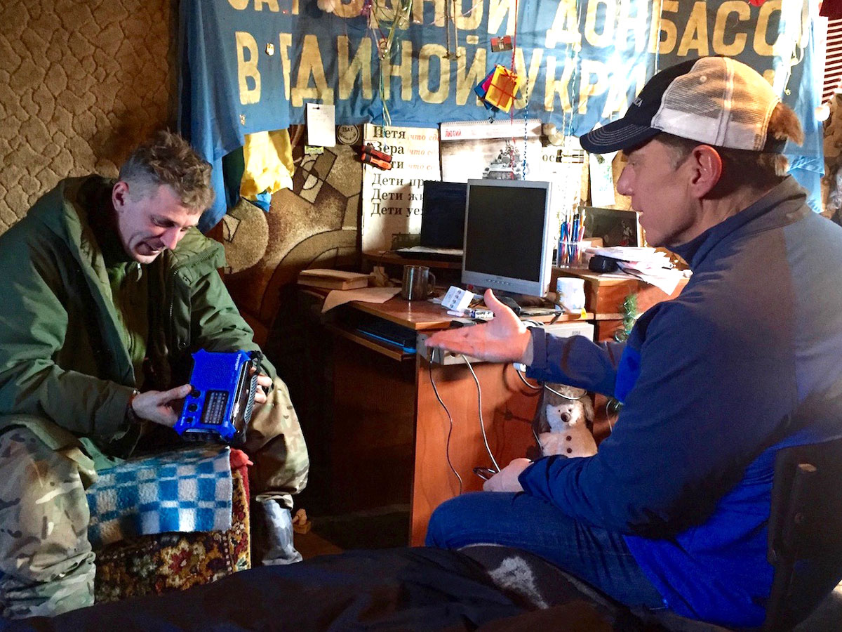 CEO Jim Hake discusses the radio project with a Ukrainian commander on the frontlines