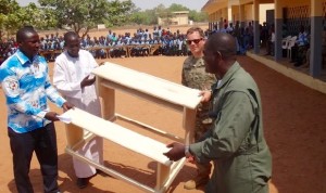 The Civil Affairs team leader in Garoua and his Cameroonian partner deliver much-needed new desks to the local school. Until now many students had to sit on the floor for class. 
