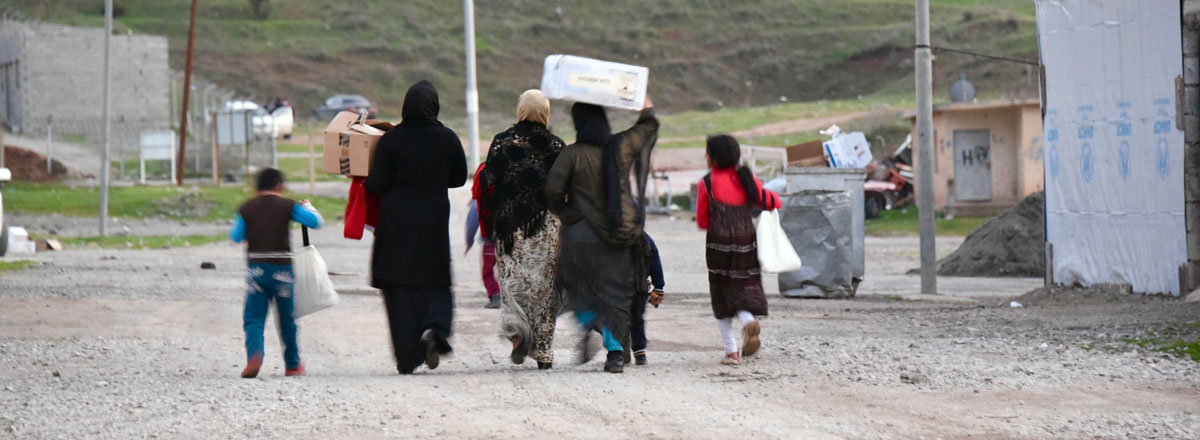 Yazidi families walking home with humanitarian supplies