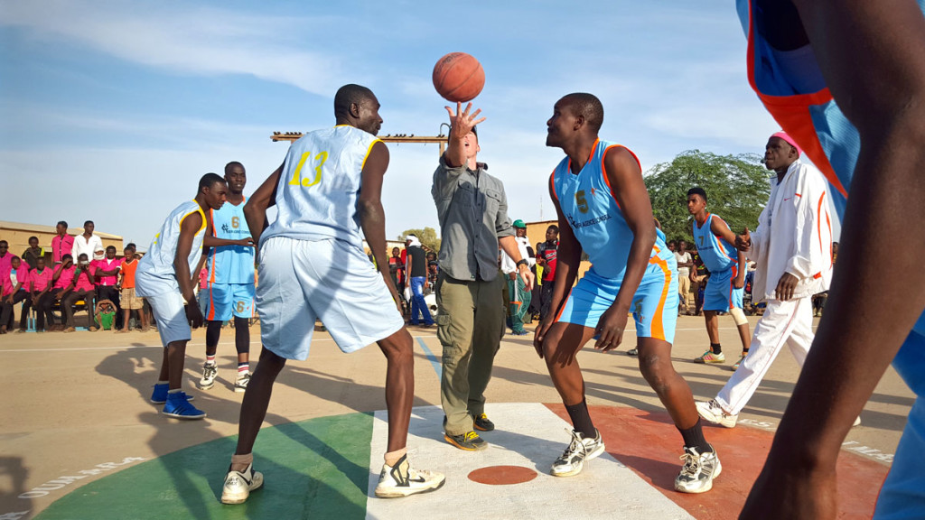 The US Civil Affairs Team Leader throws the jump-ball to start the game at the newly refurbished court in Agadez