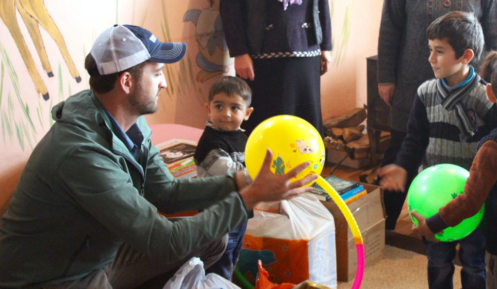 SoA's Isaac Eagan passes out toys and educational materials to refugee children