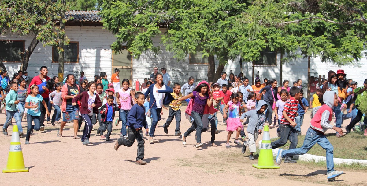 Local children run to receive donated educational supplies