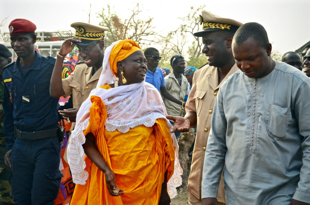 The Co-Op President (in orange, center), Regional Governor (khaki, right) , and Mayor of Kedougou (gray, far right) happily approach the warehouse after having been presented with the keys to the building