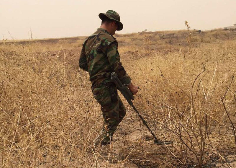 Peshmerga soldier sweeping for hidden explosives using a metal detector provided by SoA