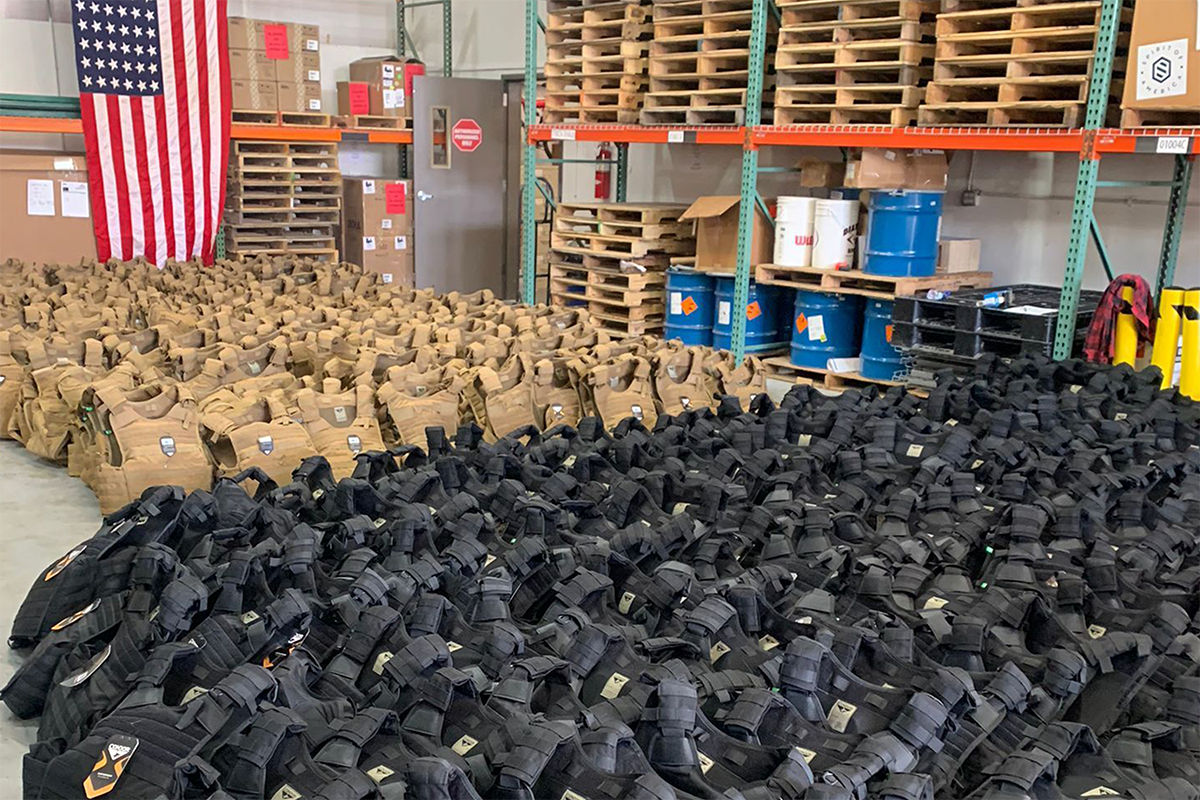 Rows of bulletproof vests lines up in a warehouse